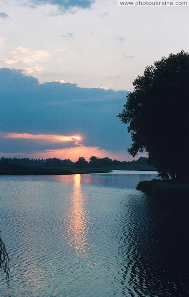 Sunset over pond in area Chudniv Zhytomyr Region Ukraine photos